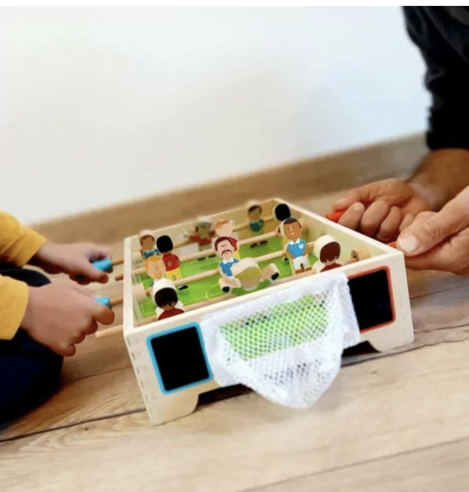 Ce mini Babyfoot en bois avec 4 rangées de joueurs (12 joueurs) et 3 balles en bois permettra à  votre enfant d'organiser des parties endiablées avec ses copains. Filets des cages amovibles par système de velcro pour pouvoir récupérer plus facilement les balles. Ardoises à côté du but pour noter les points.